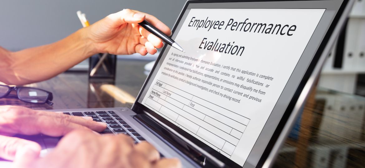 Close-up view of employee annual review form on laptop over office desk.