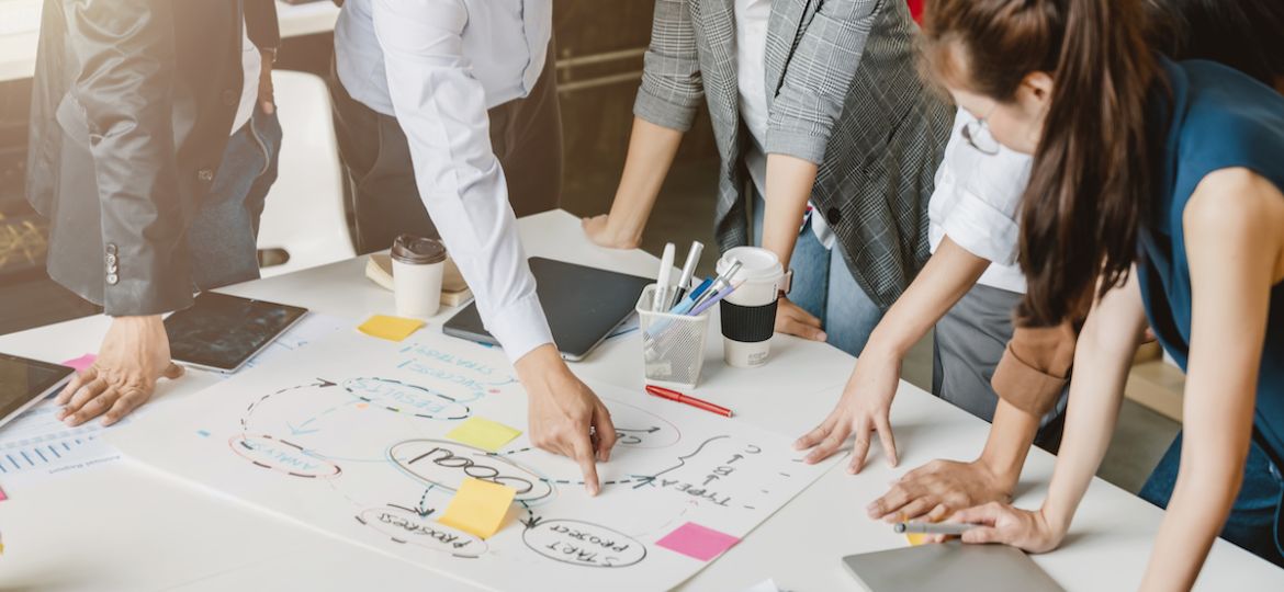 Top view of a recruiting team being lead by an HR manager outlining interview strategy and mistakes to avoid.