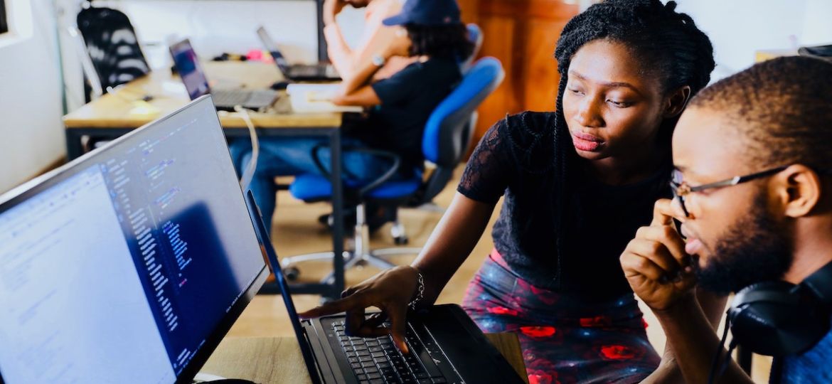 Two employees working in an office space, based on an employee referral.
