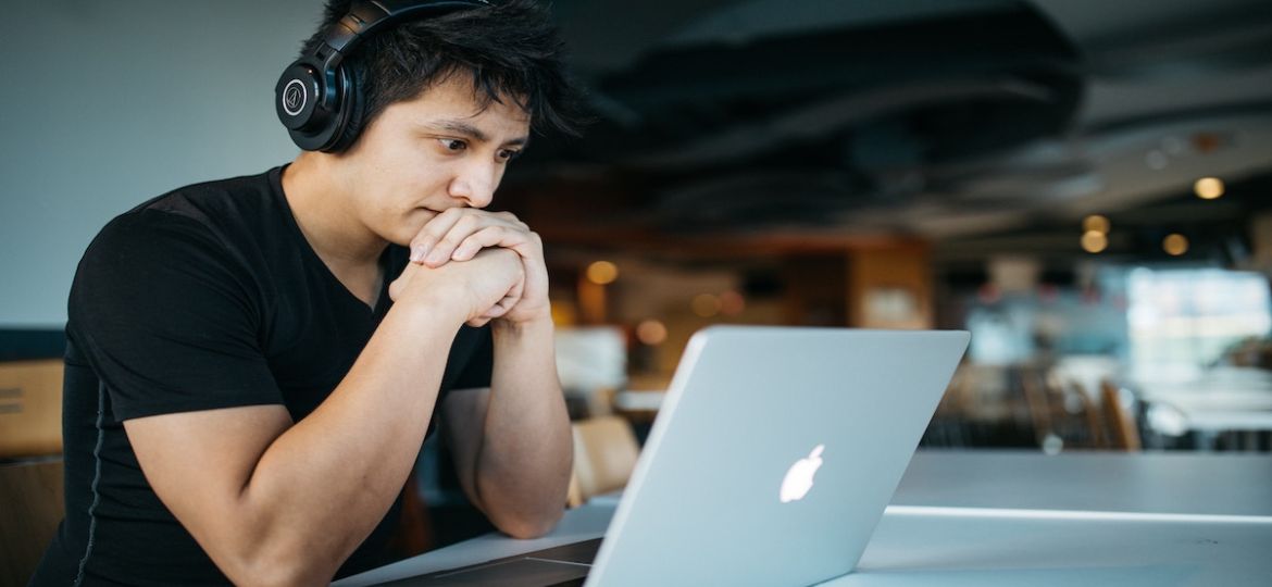 Close up of a man watching a webinar recap on his laptop.