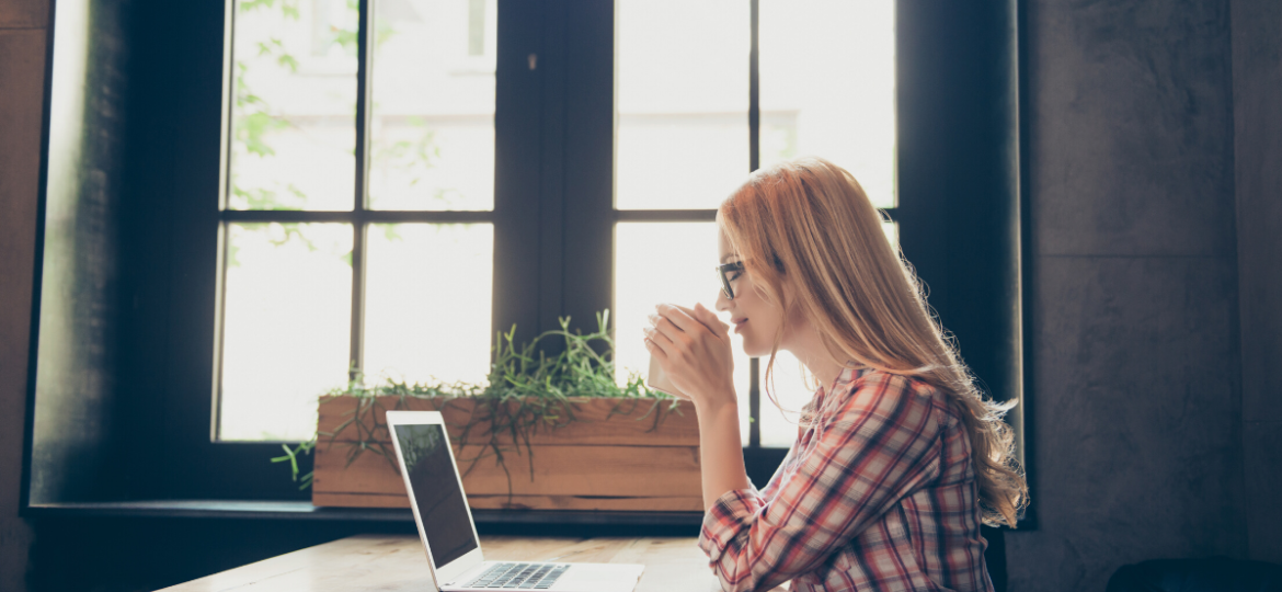 woman watching HR webinar on laptop at desk.