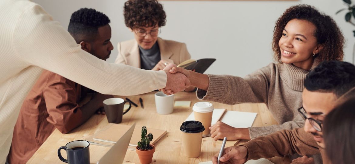 Group of employees at a business meeting discussing how their company has been named a best place to work on glassdoor's list.