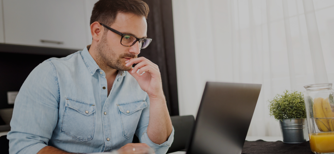 Man sitting at computer, watching HR webinar to learn how to best continue business operations during the coronavirus crisis.