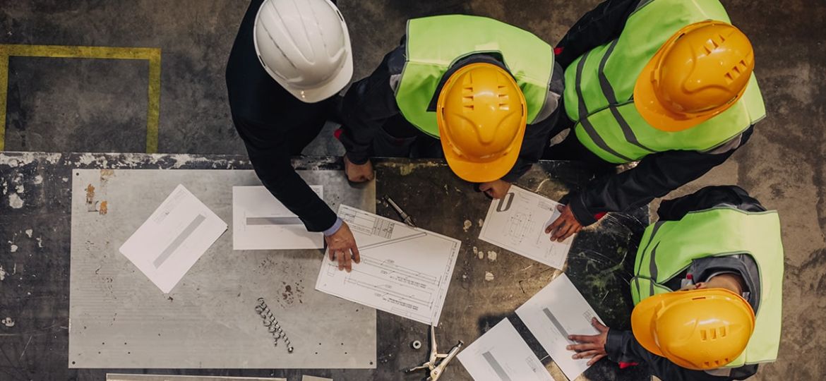 Warehouse workers around a table discussing plans